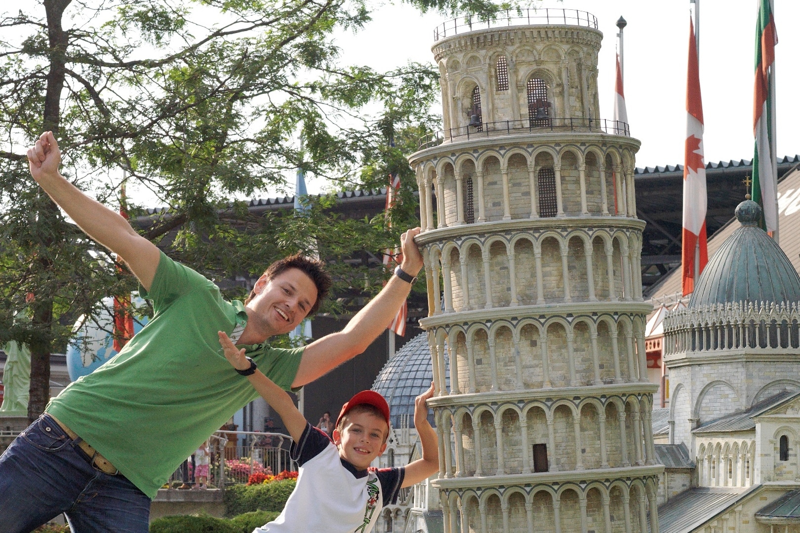 Vater und Sohn besuchen das Ausflugsziel Minimundus in Klagenfurt. Sie stehen vor dem Turm in Pisa und posieren für das Foto.