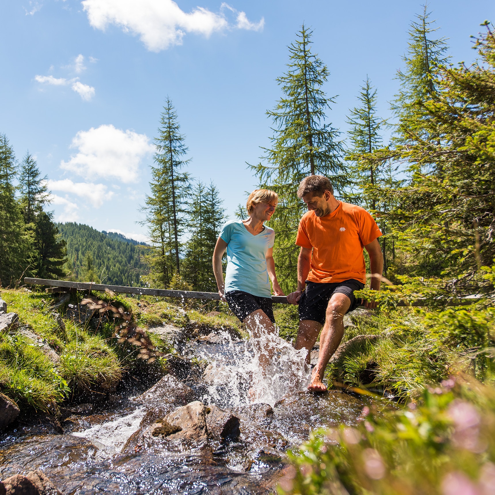 Bach Wanderurlaub Kärnten: Ein Paar planscht barfuß im Bach